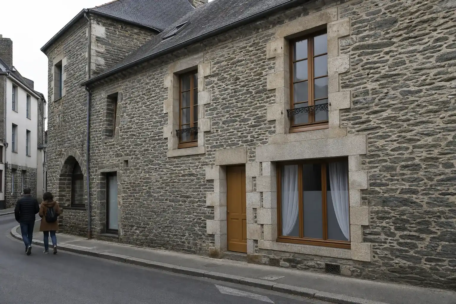Façade rennaise en pierre de schiste vert-gris, joints à la chaux et toiture d'ardoise, dans une rue calme au petit matin